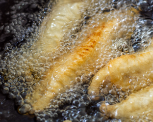 Flour coated fish frying in oil